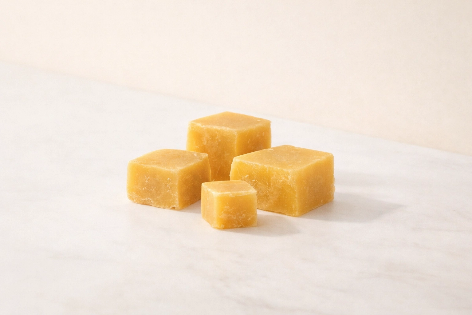 Natural lip balm with beeswax sitting next to raw honeycomb on a clean marble surface.