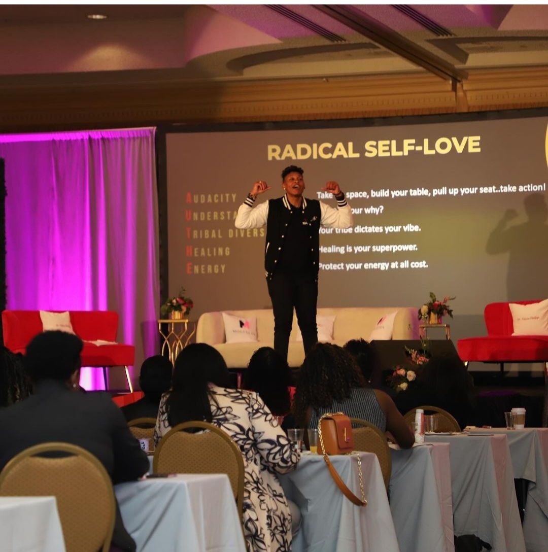 Empowerment keynote session showcasing radical self love and wellness themes at a professional event.