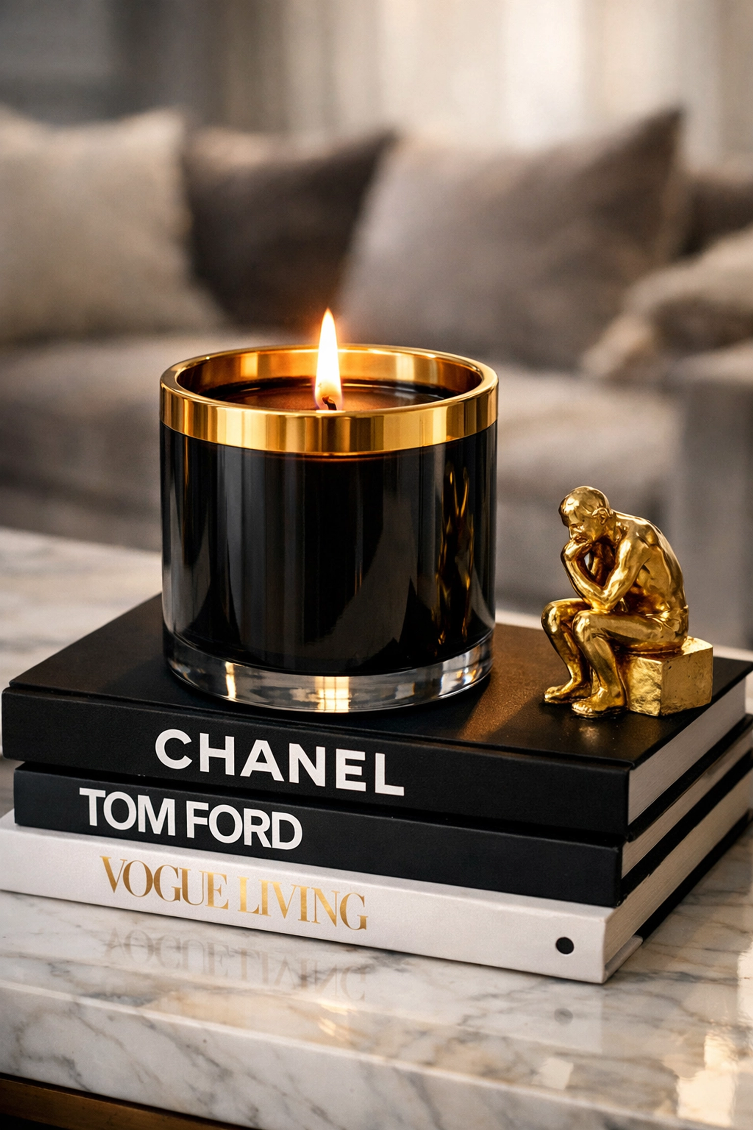 Luxury lit candle and home decor items from a Black-owned lifestyle brand on a marble surface.