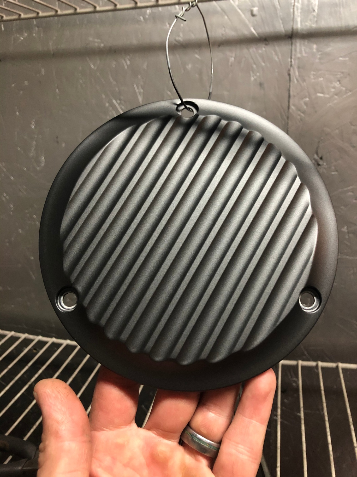 Matte textured black motorcycle engine cover with a protective finish designed to resist salt corrosion