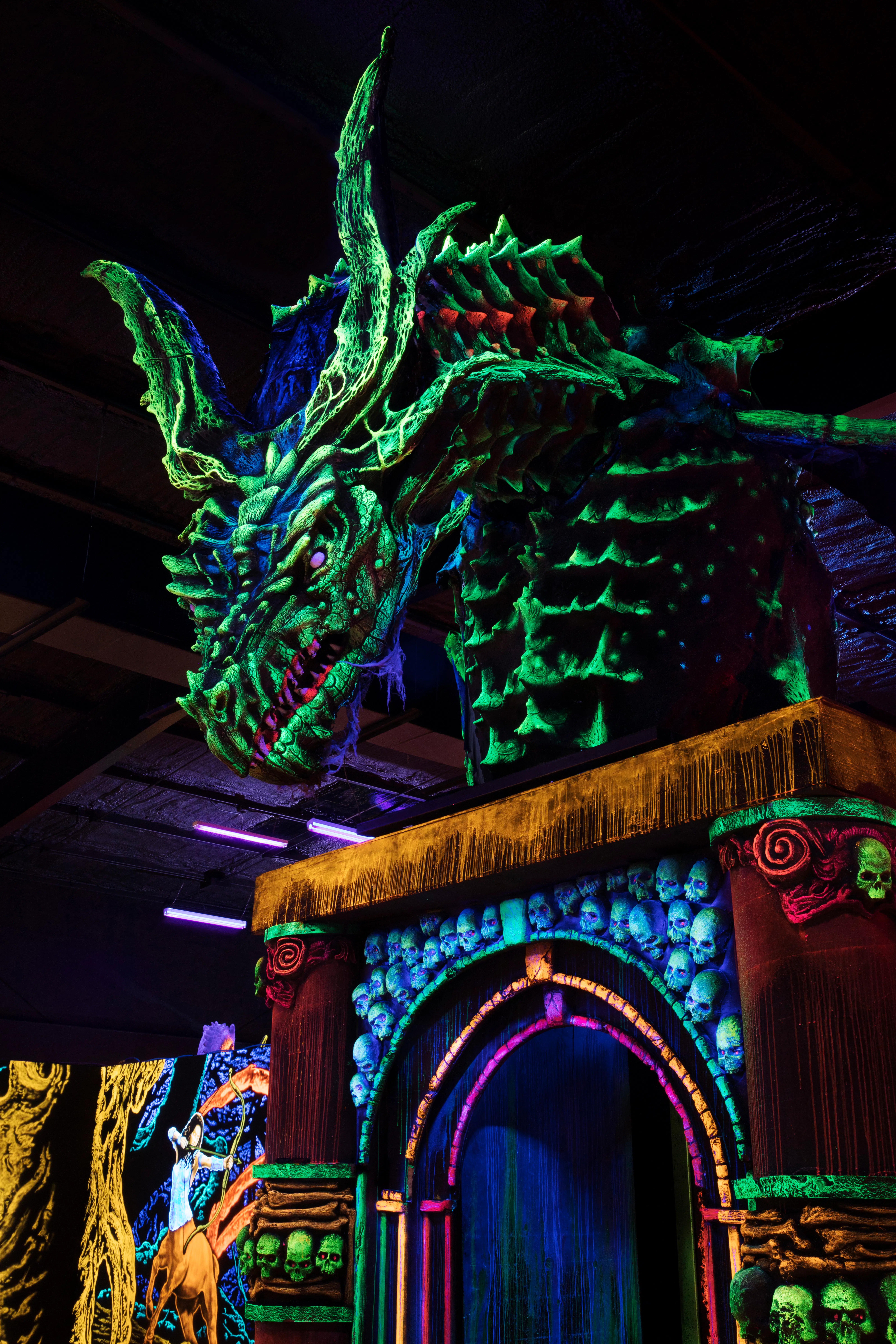 Dragon Gate at Cooper’s Kingdom—blacklight mini golf entrance with a glowing dragon welcoming brave families into the quest.