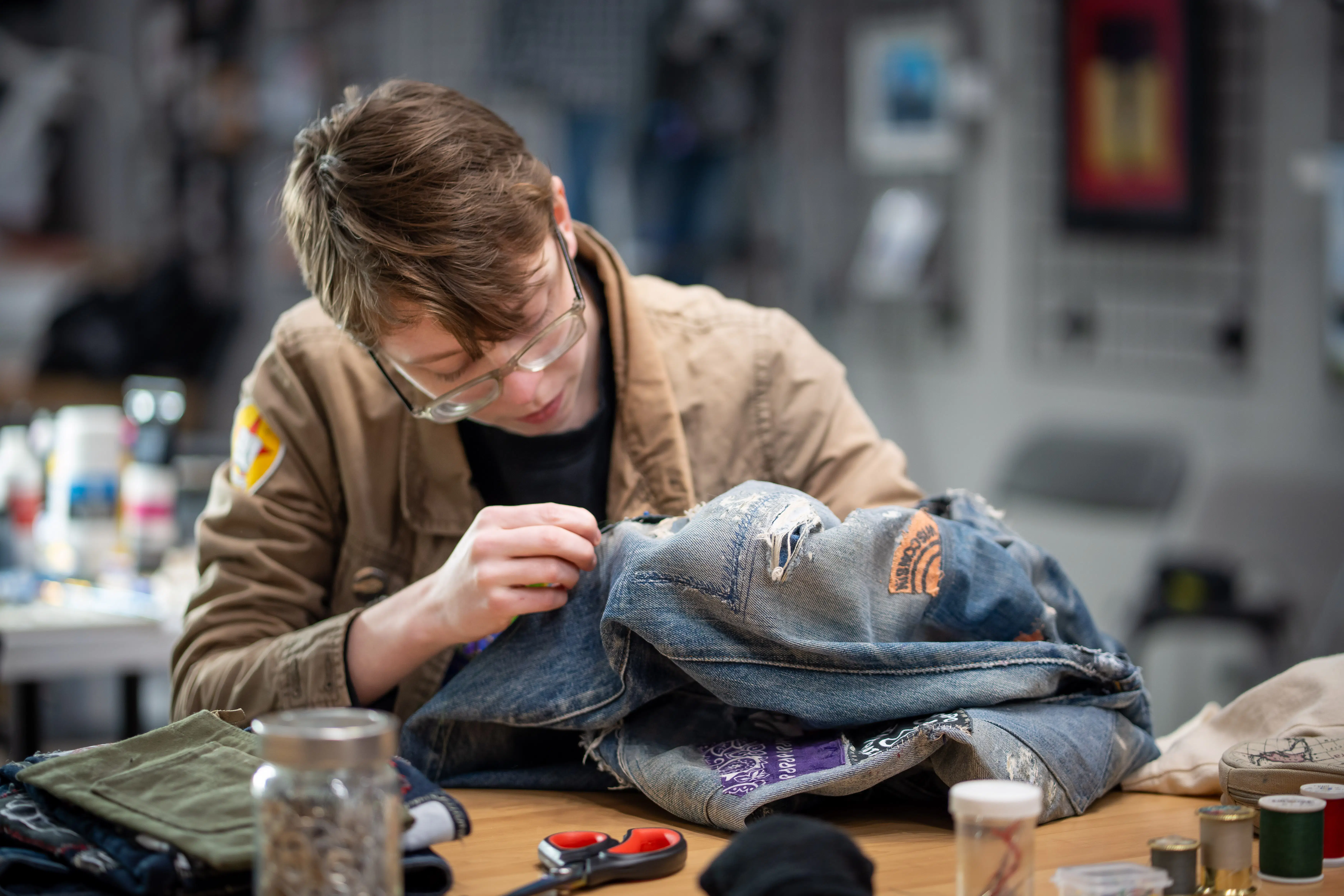 [PHOTO] An artist at work hand-stitching a denim jacket for the Keyport Fashion Show