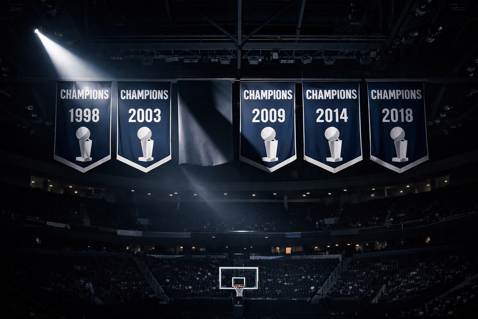 Spotlight on UConn championship banners in a dark arena, highlighting the program’s legacy and standard.
