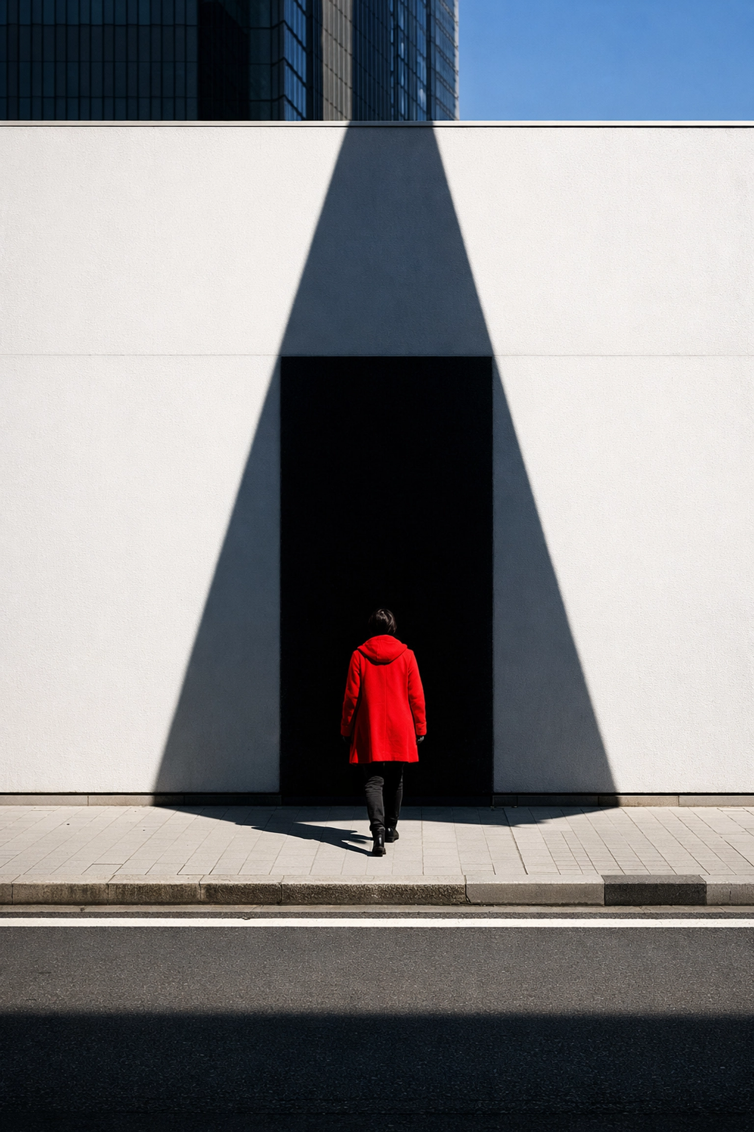 Street photography composition showing a person in red walking through high-contrast shadows.